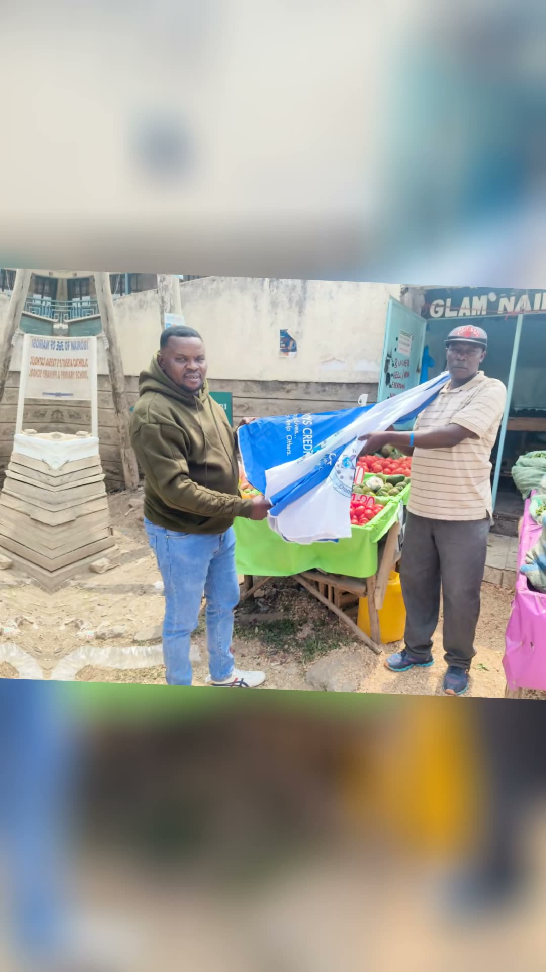 Kenya Skys Credit representative handing branded stall material to a local produce trader